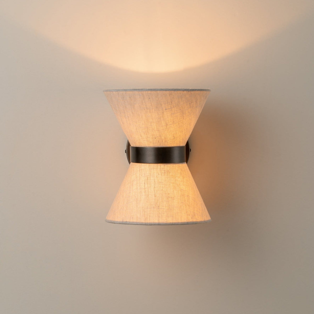 Klassisch-moderne Wandleuchte mit gealtertem Bronze-Finish und Leinenschirm