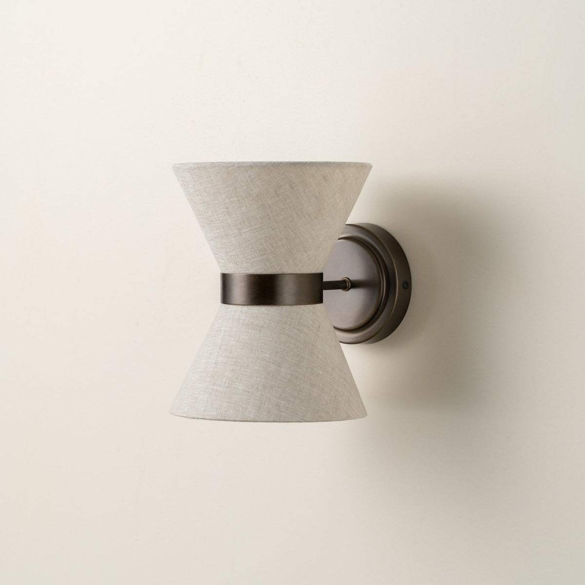 Klassisch-moderne Wandleuchte mit gealtertem Bronze-Finish und Leinenschirm