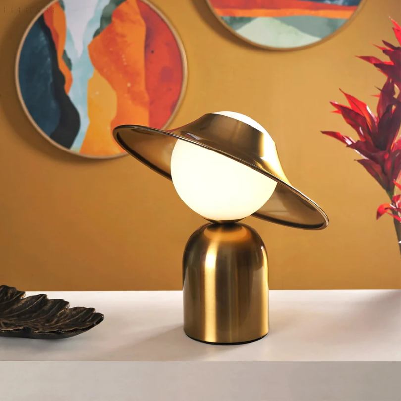 Elegante goldfarbene Metall-Tischlampe mit geneigtem Kopf und warmem Licht