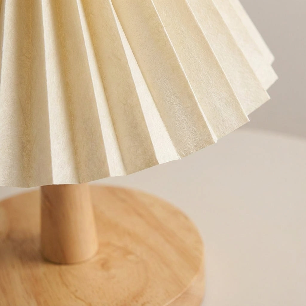 Wiederaufladbare skulpturale Tischlampe mit faltbarem Plisseeschirm und Holzsockel