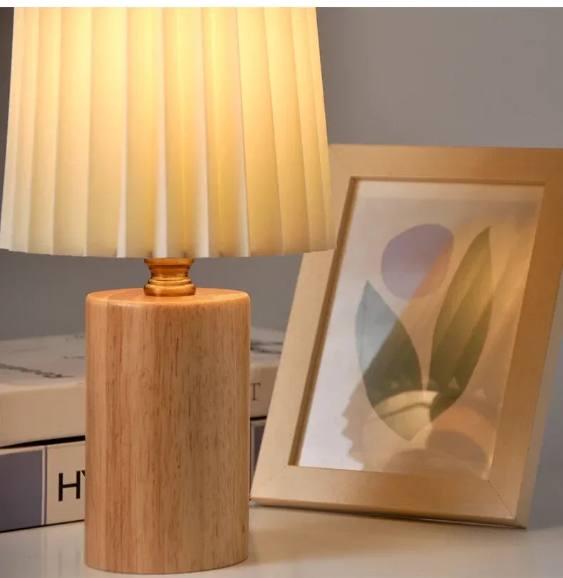Tischlampe mit Plisseeschirm aus Stoff und Sockel aus Massivholz