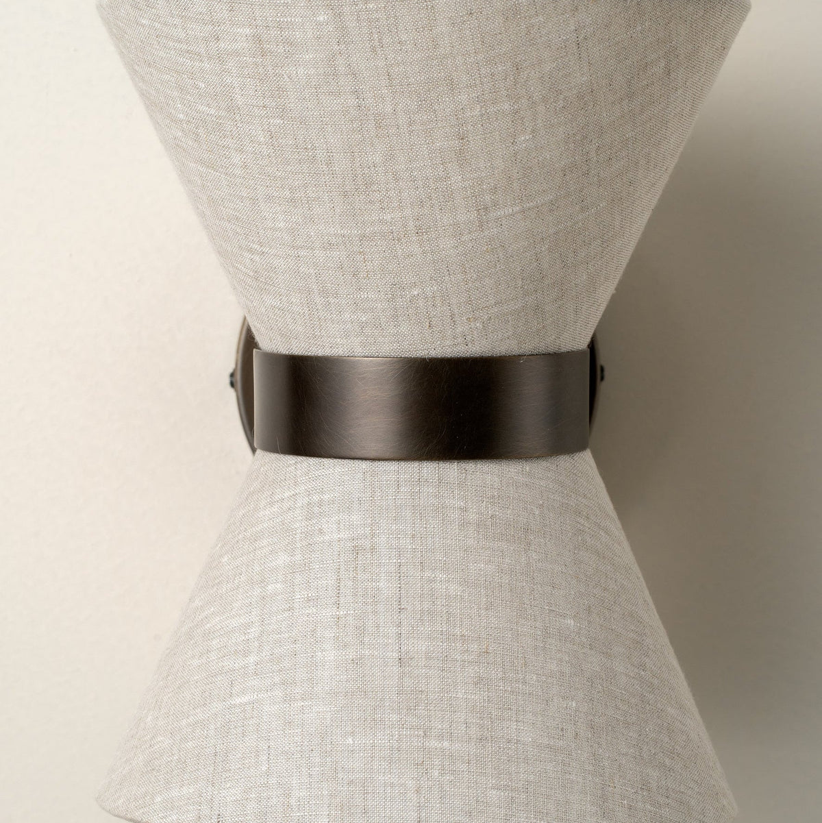 Klassisch-moderne Wandleuchte mit gealtertem Bronze-Finish und Leinenschirm