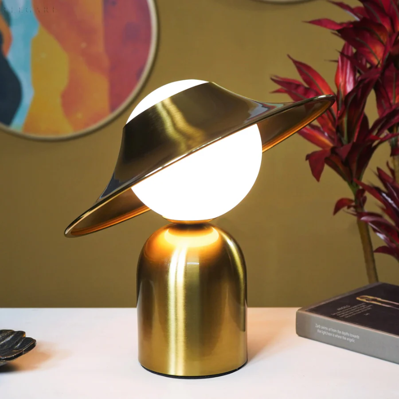 Elegante goldfarbene Metall-Tischlampe mit geneigtem Kopf und warmem Licht