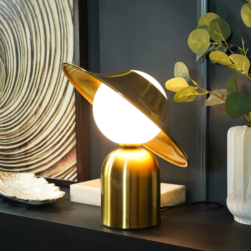 Elegante goldfarbene Metall-Tischlampe mit geneigtem Kopf und warmem Licht